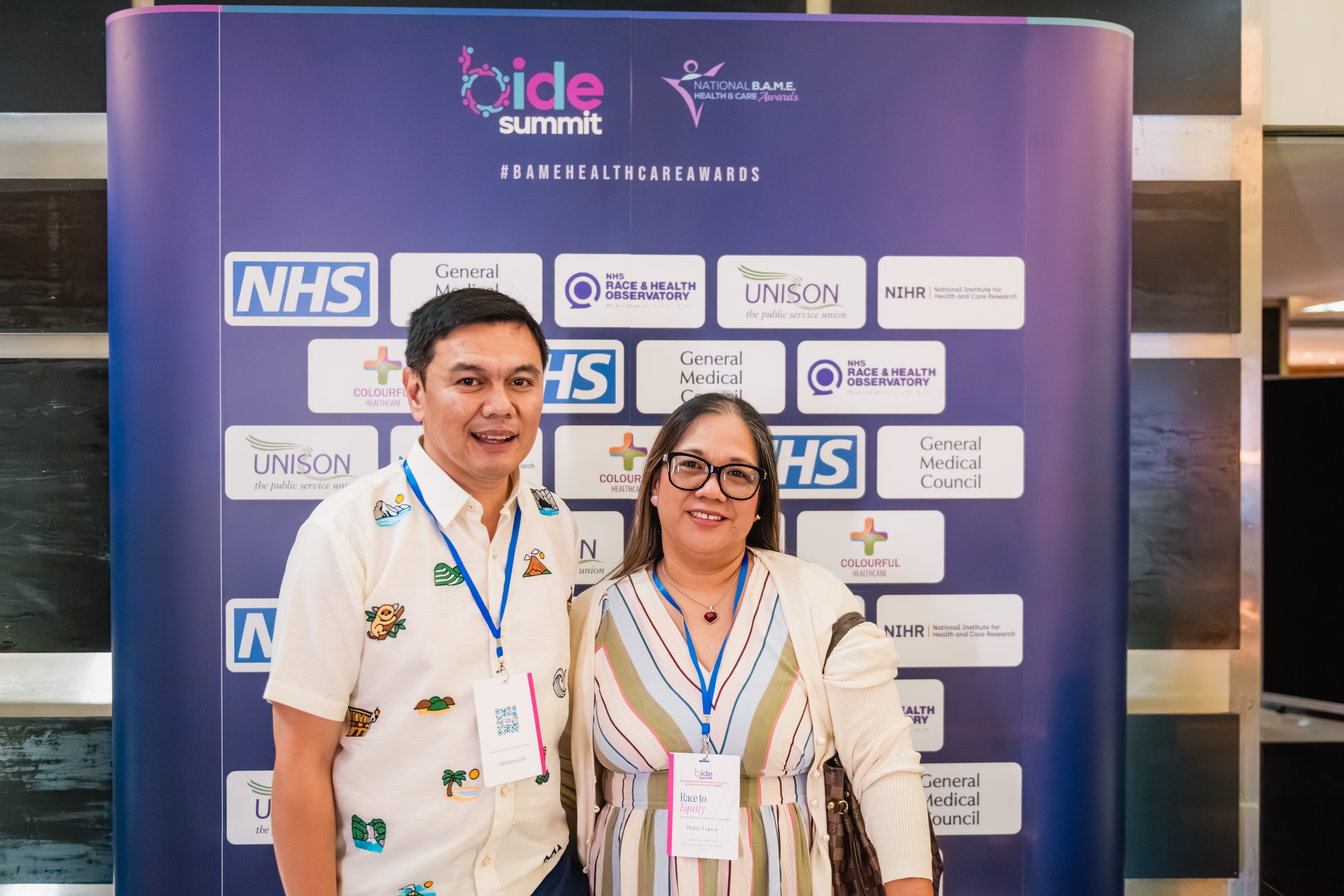 B.I.D.E summit delegate pair at the sponsor backdrop
